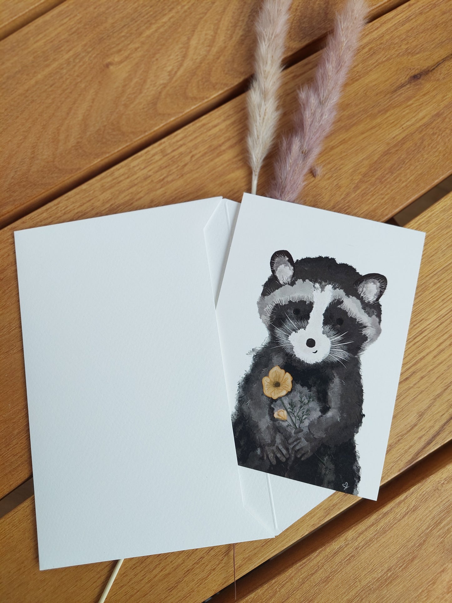 Die Postkarte Waschbär steckt halb in einem Briefumschlag A6 Format. Tolles Motiv als persönliche Aufmerksamkeit für Kinder oder Erwachsene z.B. zum Geburtstag, Muttertag, Kindertag oder zu Ostern.