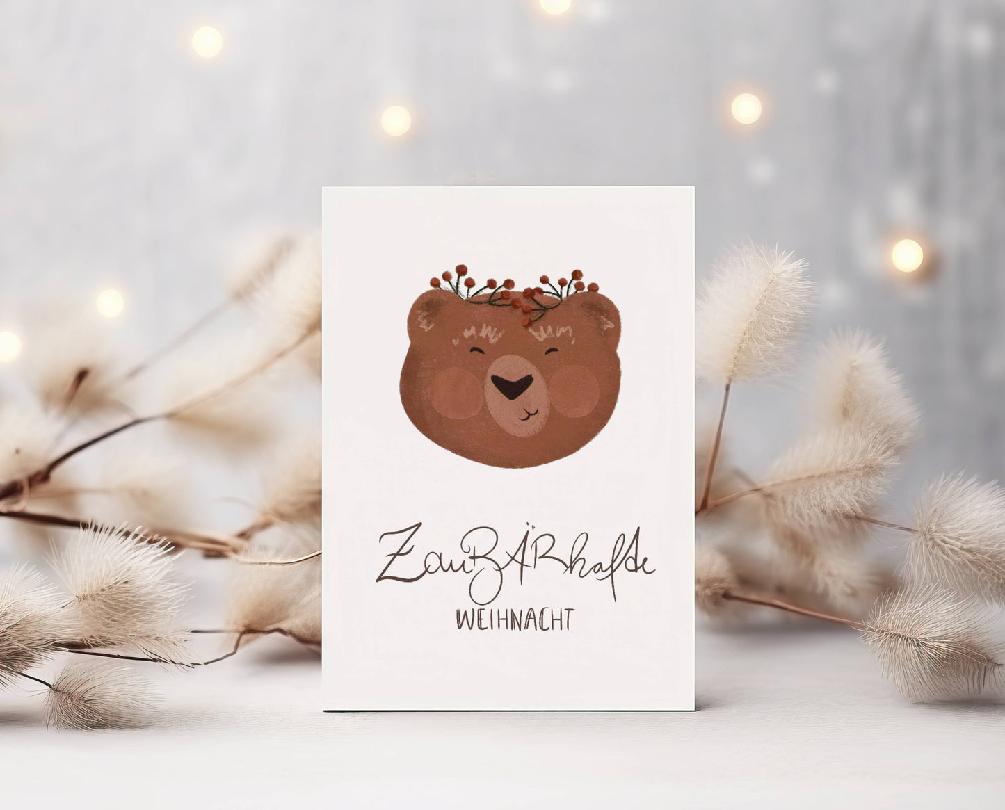 Grüße und Wünsche zu Weihnachten auf diese süße selbstgemalte Karte. Aquarell-Kreide-Zeichnung. Ein schmunzelnder Bärenkopf mit rosa Wangen und roten Waldbeeren auf dem Kopf. Darunter der Spruch: ZauBÄRhafte Weihnacht