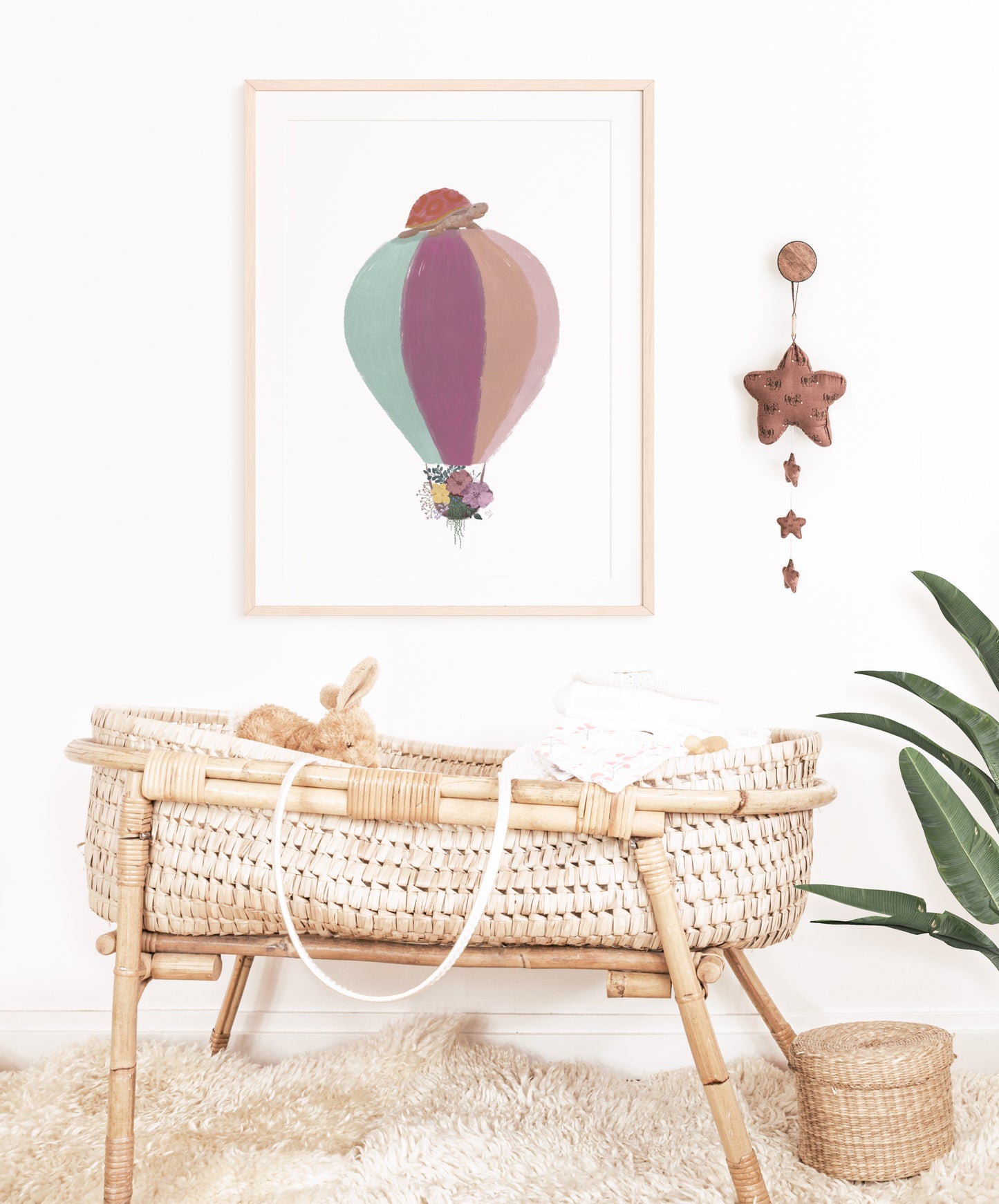 Kinderzimmerdeko Ballonfahrt mit Schildkröte und Blumen hängt über einem Babybett. Geschenk zur Geburt. Dekoidee für das Kinderzimmer.