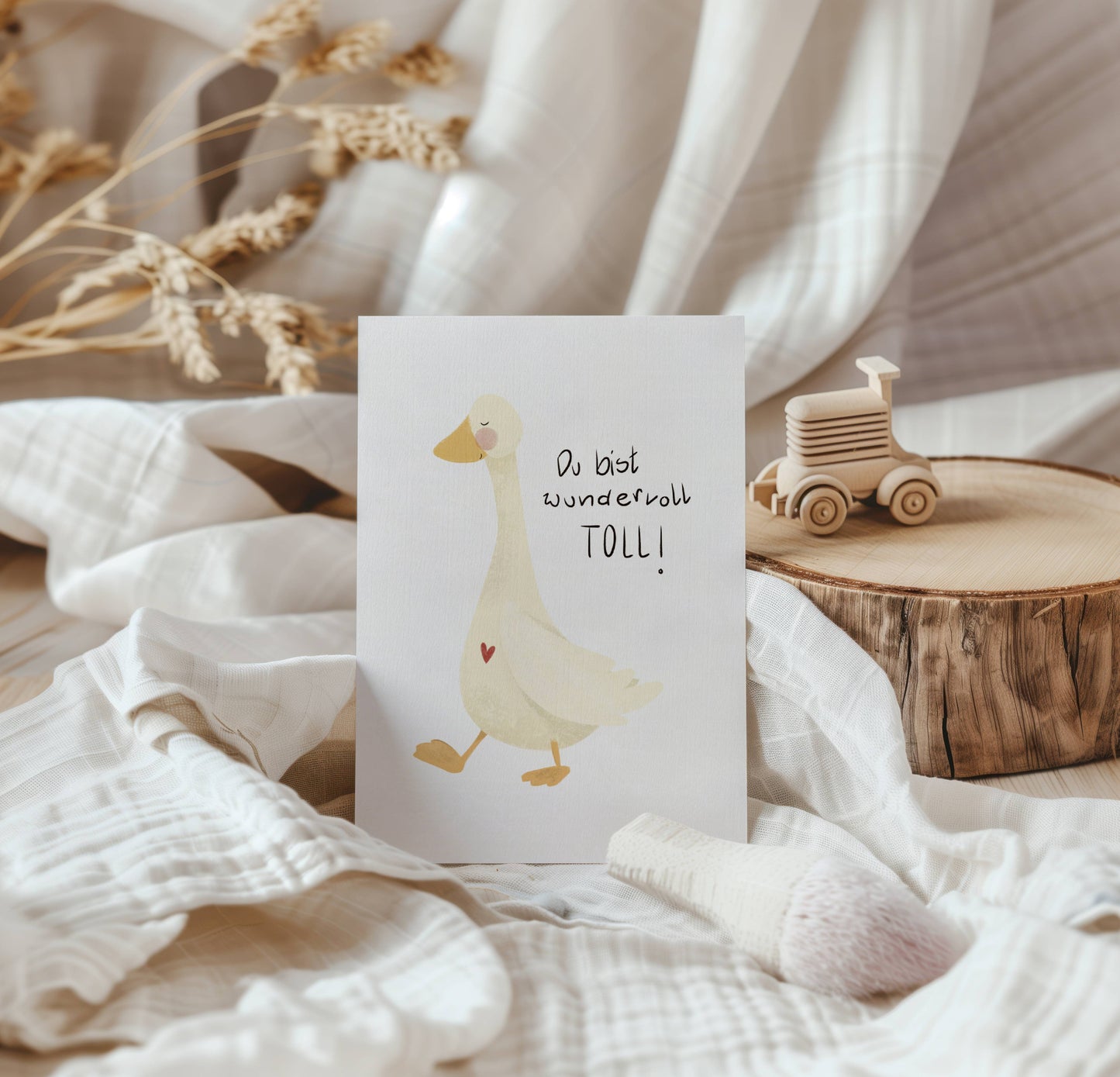 Postkarte Gans mit Spruch: Du bist wundervoll toll. Von Hand gezeichnet. Karte zur Geburt, zum Geburtstag, als Geschenk für Mama, Papa, Freunde. Die Karte steht angelehnt an einen Birkenstamm neben einem kleinen Holzauto.
