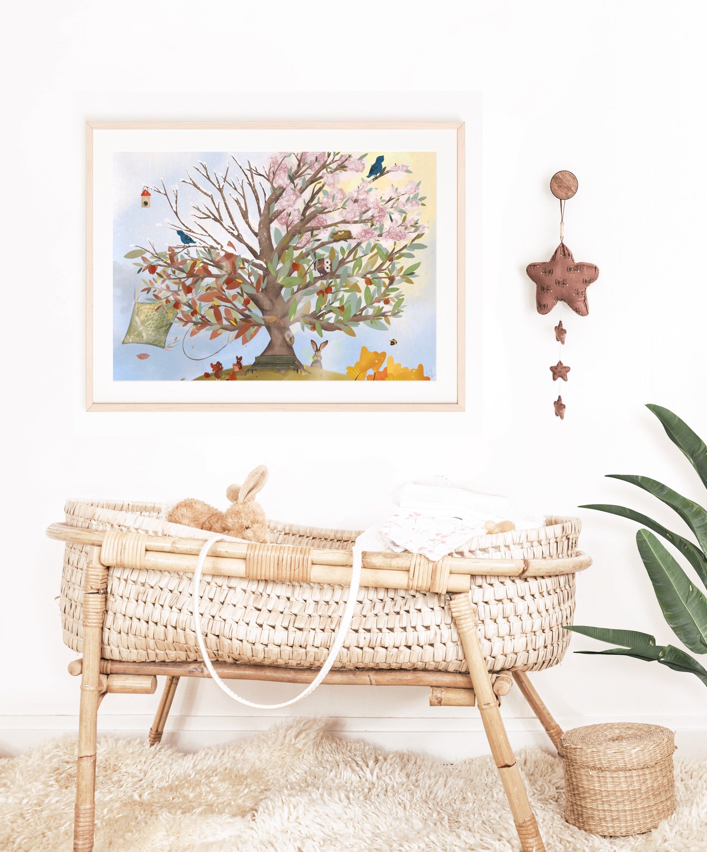 Kinderzimmerdeko Jahreszeitenbaum hängt über einem Babybett. Geschenk zur Geburt. Dekoidee für das Kinderzimmer.