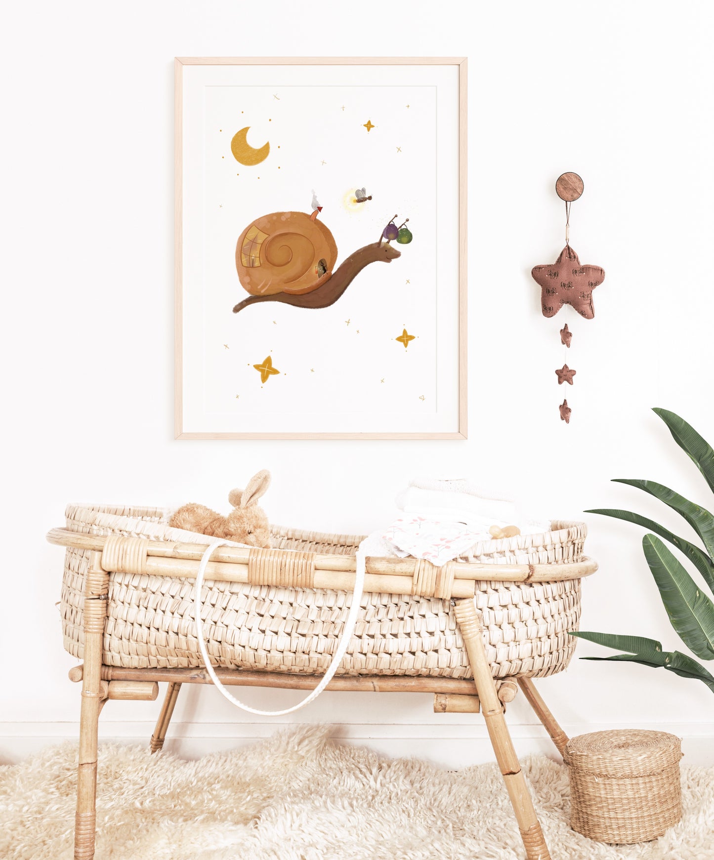 Wanddeko für das Kinderzimmer. Kinderposter Schnecke hängt über einem Babybett.