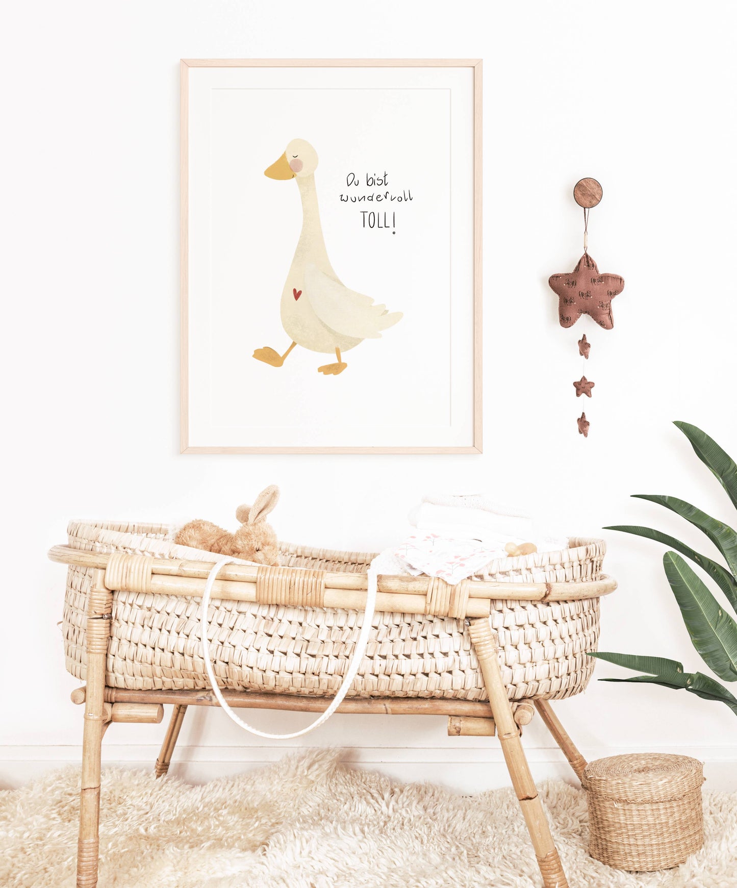 Kinderzimmerdeko Gans mit liebevollem Spruch hängt über einem Babybett. Geschenk zur Geburt. Dekoidee für das Babyzimmer.