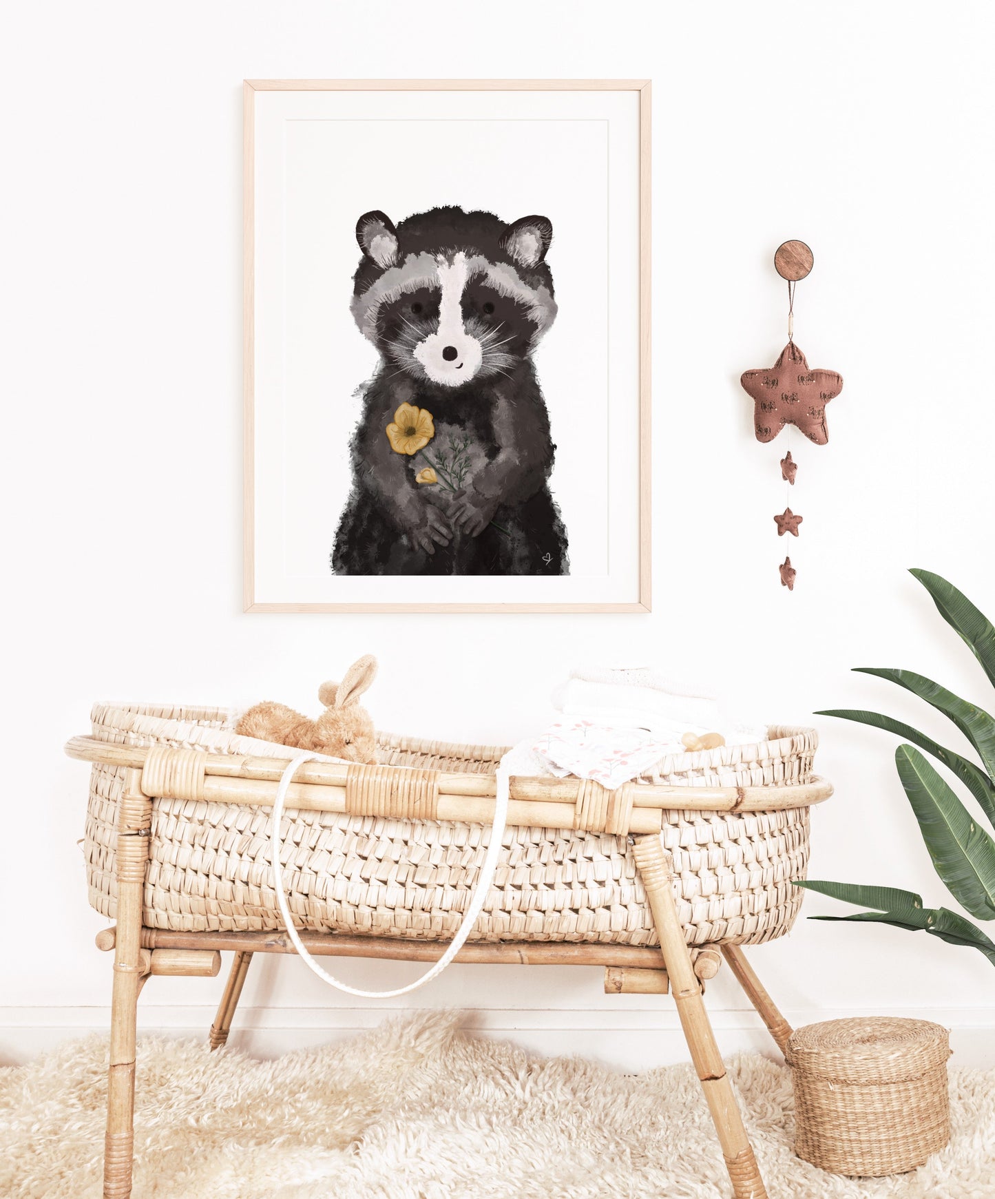 Kinderposter freundlicher Waschbär hängt über einem Babybett. Geschenk zur Geburt. Dekoidee für das Kinderzimmer.